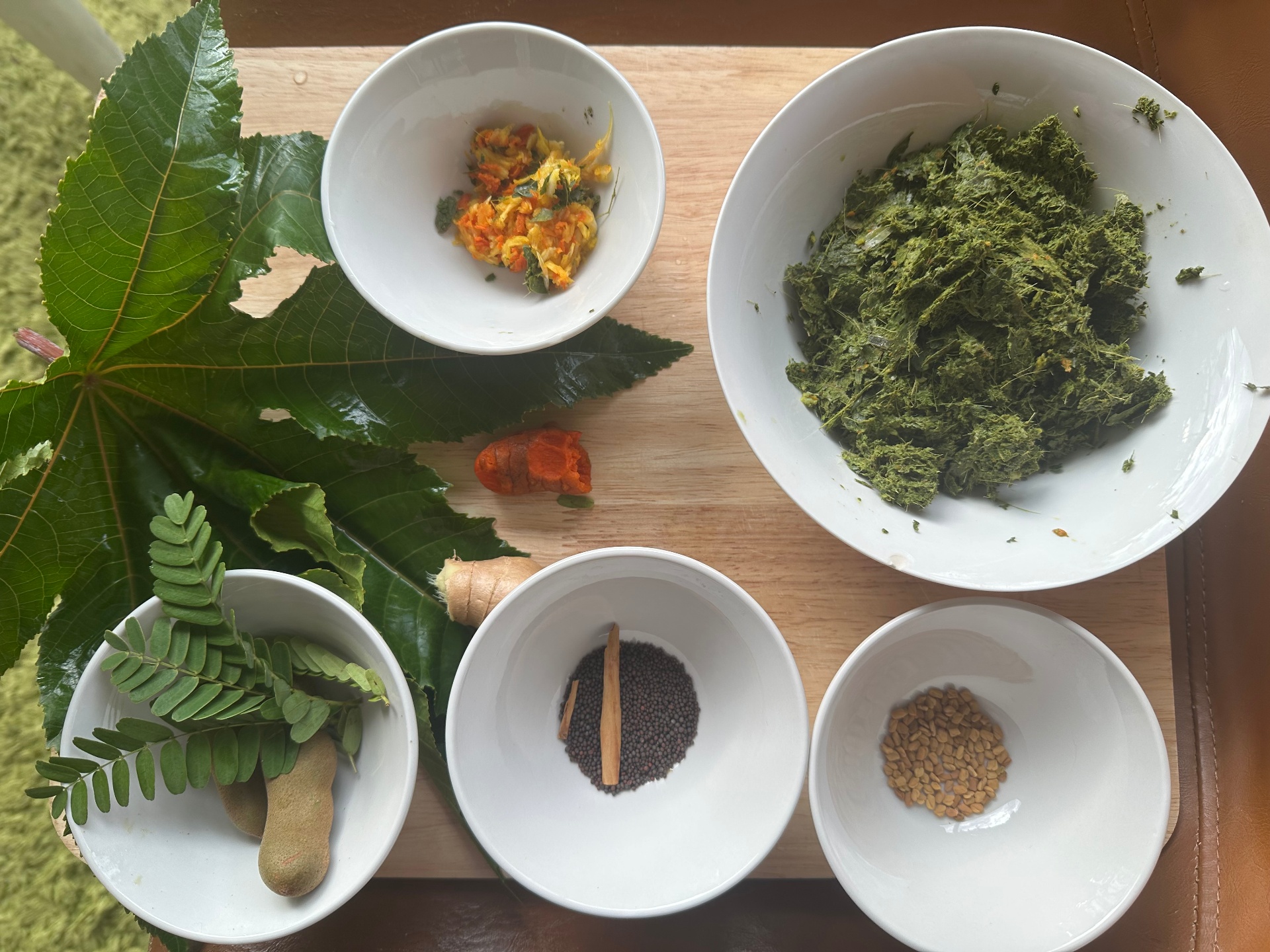 Ayurvedic herbs and ingredients arranged in bowls